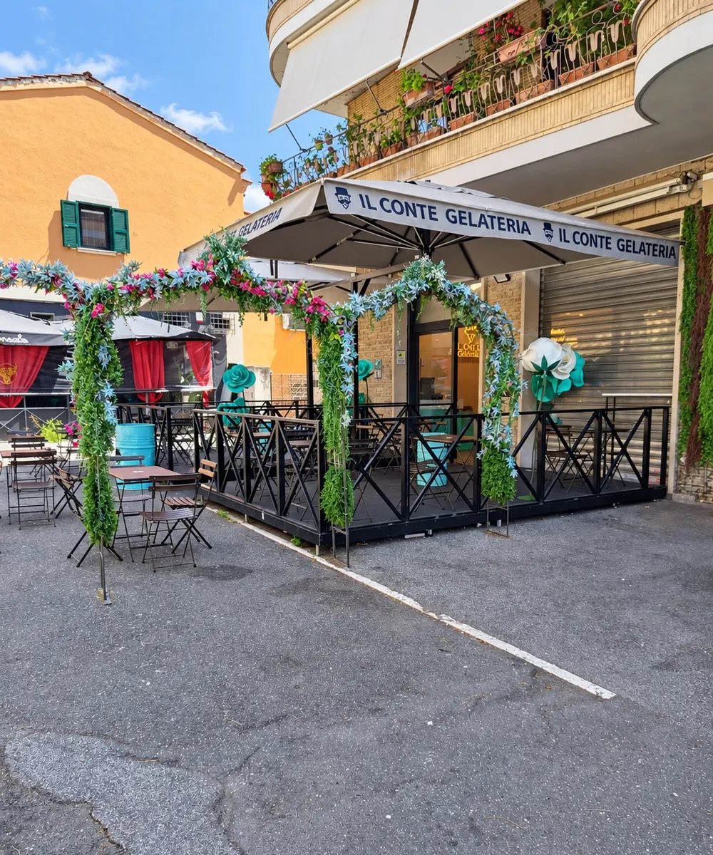 Il dehors della gelateria di giorno, con l'insegna, l'arco verde e le rose color Tiffany