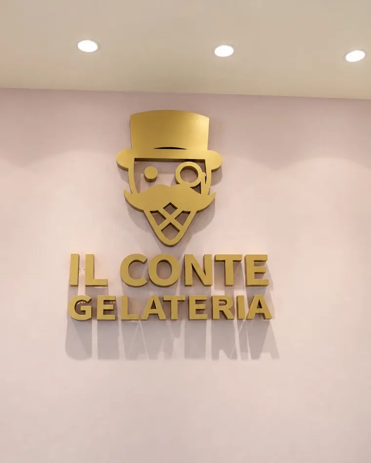Il logo dorato «Il Conte Gelateria» sulla parete rosa