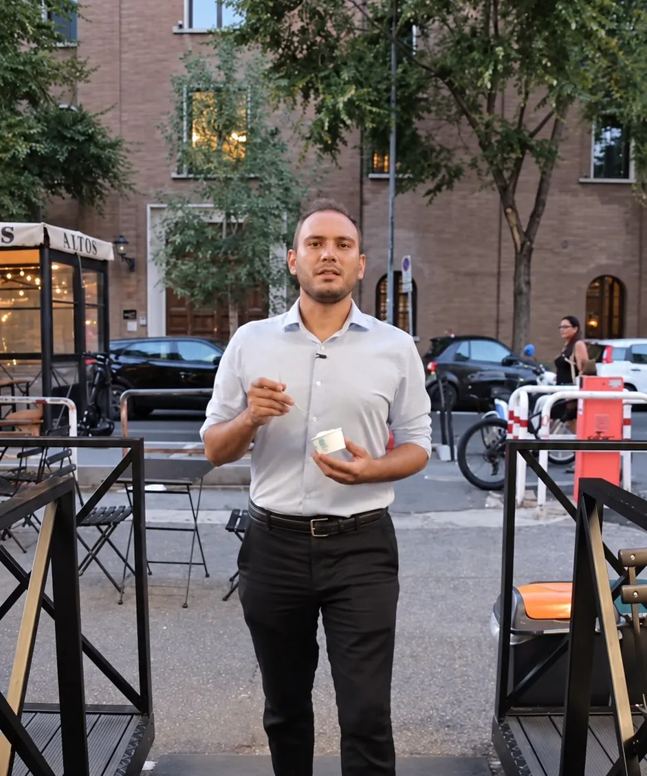 Un cliente esce col gelato dal dehors della gelateria, la sera a Ponte Milvio