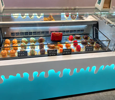 La vetrina con la frutta realistica e una borsetta rossa di gelato